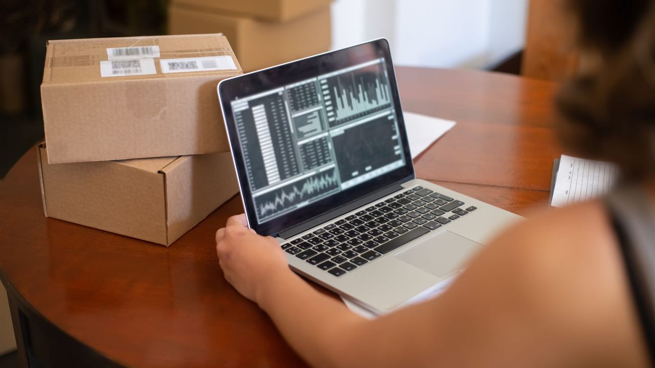 Small business owner reviewing online orders and website activity on a laptop