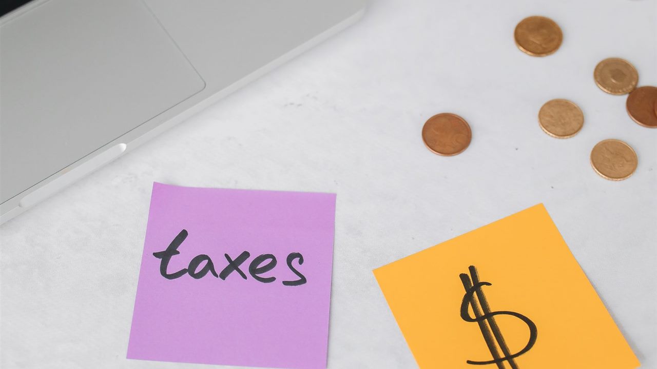 Website cost planning with laptop notes and coins for Jamaica business owners