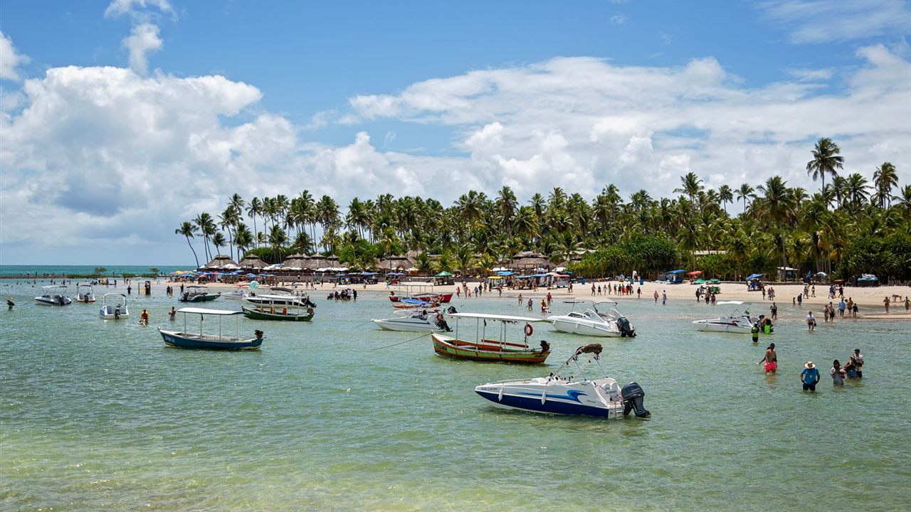 Tropical beach with boats and tourists for Jamaica tour company website design